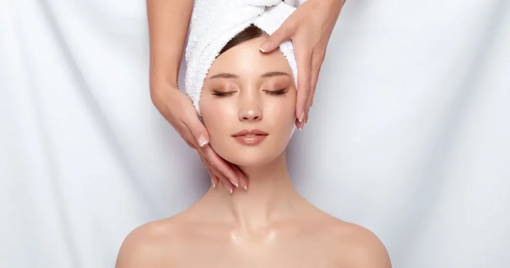 Woman receiving a relaxing facial treatment in Evans, GA, with a towel wrapped around her hair.